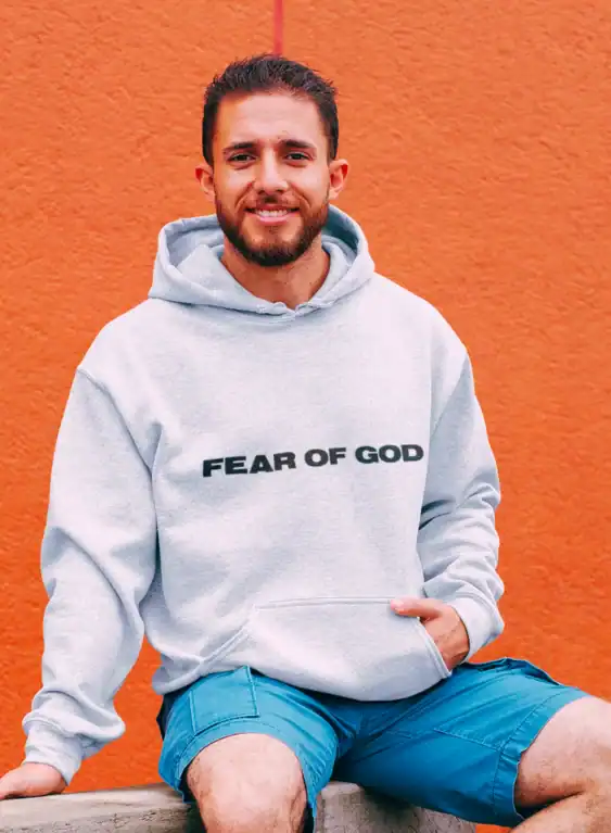 Cheap apparel hoodie with "FEAR OF GOD" printed, casual streetwear style, men's fashion, affordable everyday clothing.